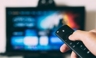 A person holds a remote while watching a streaming service.