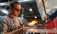 A lampworking artist works the torch at Skylab Glass Arts