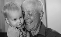 A grandfather holds his grandson in this Focus on Maple Grove winning photograph.