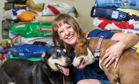 Amy Arellano, founder of pet food nonprofit Feeding Furry Friends, pets two of her dogs.