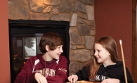 Riley and Brooke Cassibo play mancala in their fireside game room.