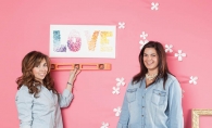 Erin Monasterio, left, and Becca Scott hang handmade ombre canvas art made of paint chip color samples in the shape of tiny butterflies.
