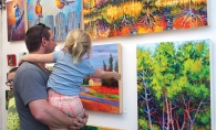 A man and his daughter look at some art at the Spirit of the St. Croix Art Festival.