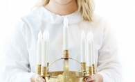 A woman holds a crown of candles for the St. Lucia concert at the American Swedish Institute