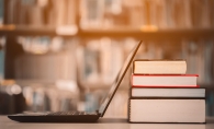 A laptop rests against some books at a library.