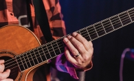 A musician plays a guitar at the Maple Grove Concert on the Lawn in Central Park.