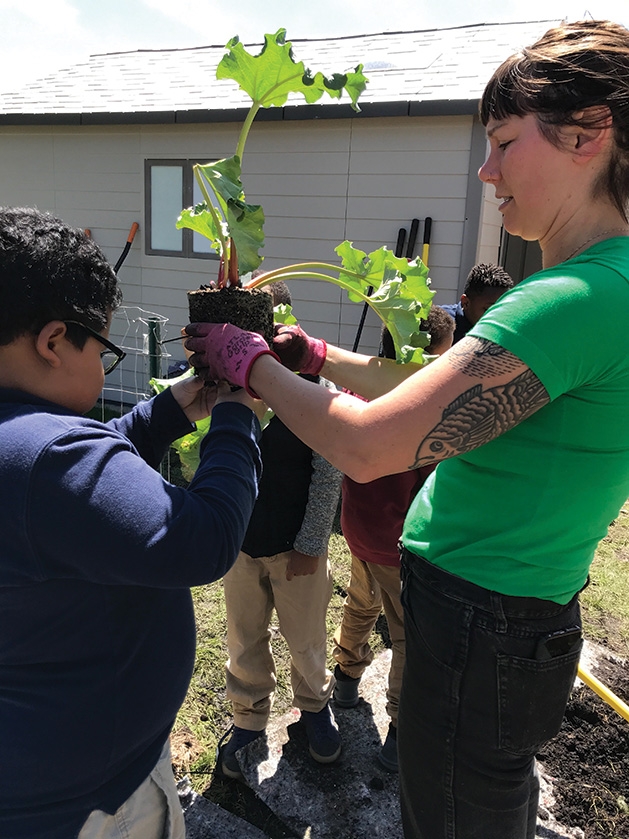 GROW teacher Linda Vale demonstrates transplanting to Minnesota Excellence in Learning Academy students.