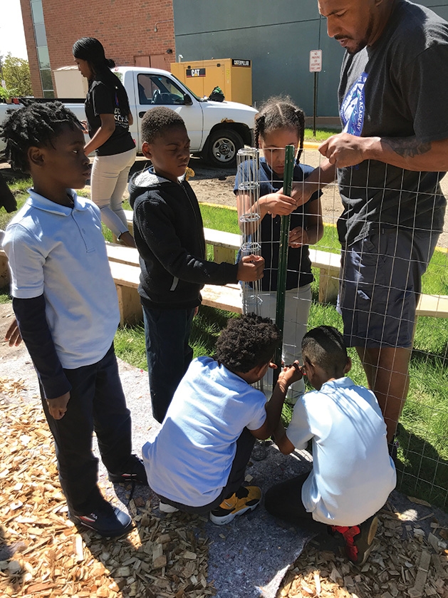 Minnesota Excellence in Learning Academy Students help put up a fence for the GROW garden.