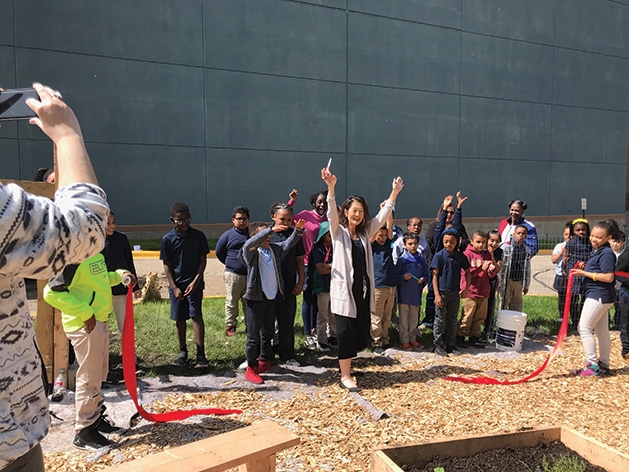 Minnesota Excellence in Learning Academy Principal Ms. Markworth celebrates after cutting a ribbon during the celebration with GROW.