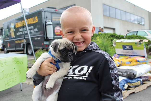 A child holds a puppy at the Feeding Furry Friends Family Fun Day.