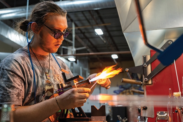 A lampworking artist works the torch at Skylab Glass Arts