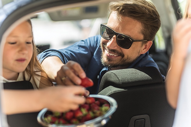 A family enjoys some strawberries during holiday travel.