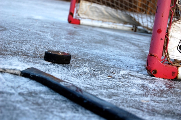 On the Ice A hockey stick and puck rest in front of the net on an ice rink in Maple Grove.