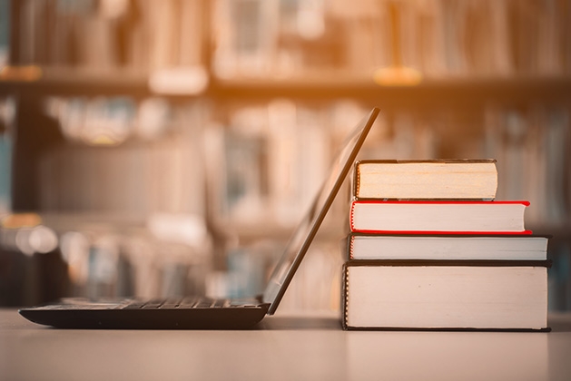 A laptop rests against some books at a library.