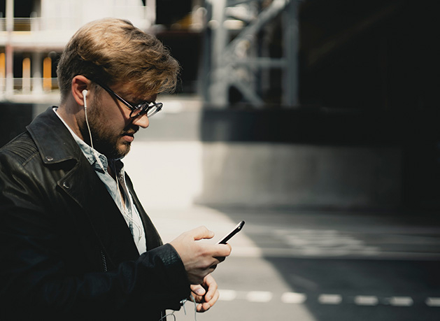 A man listens to trivia podcasts on his phone.