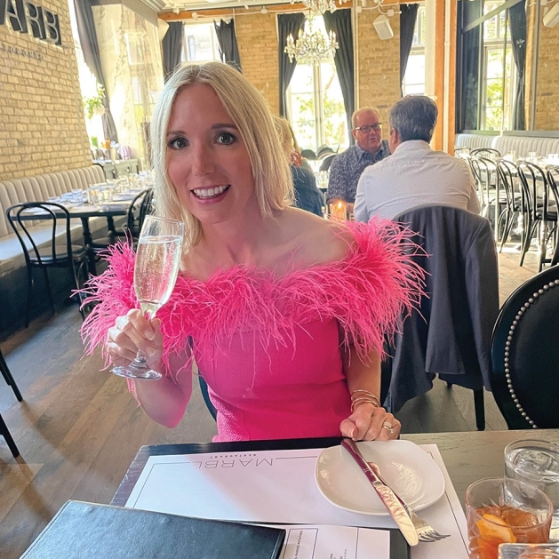 Nikki Steele wearing a pink dress with feather trim.