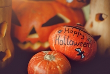 A pumpkin painted with the words "Happy Halloween" at the Maple Grove Arts Center Monster Art Show.