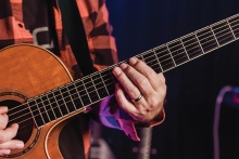 A musician plays a guitar at the Maple Grove Concert on the Lawn in Central Park.