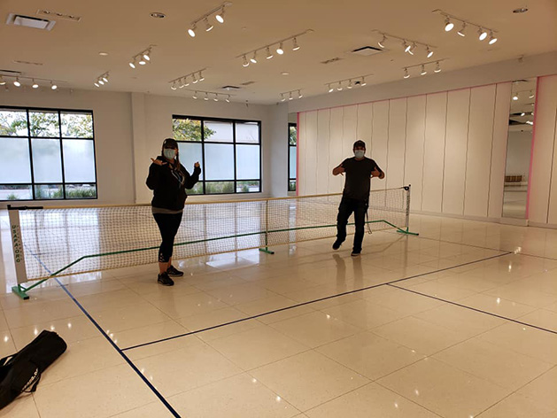 Two people on the pickleball courts at the new recreational space at The Shoppes at Arbor Lakes.